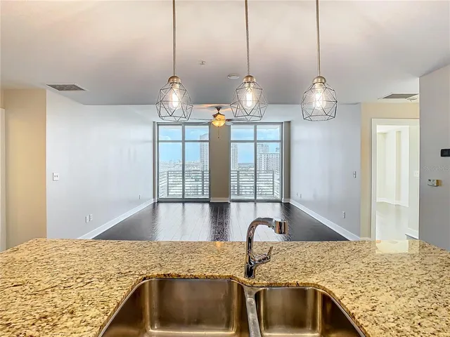 a kitchen with stainless steel appliances wooden floor and a refrigerator