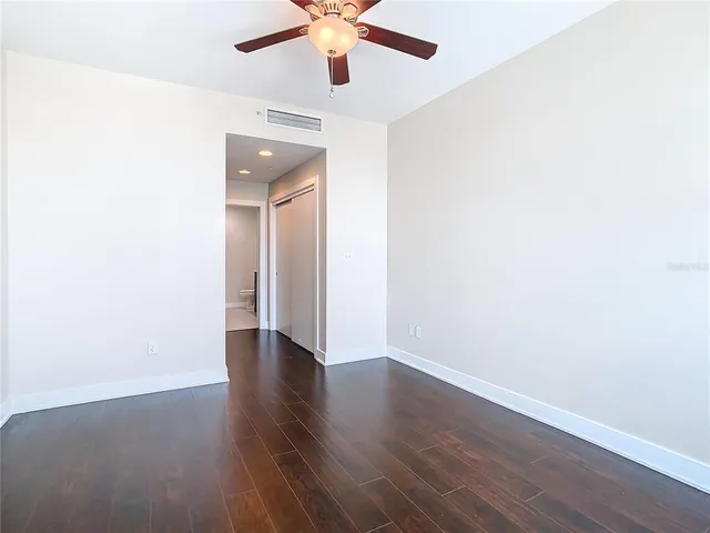 a spacious bathroom with a double vanity sink a toilet and a mirror