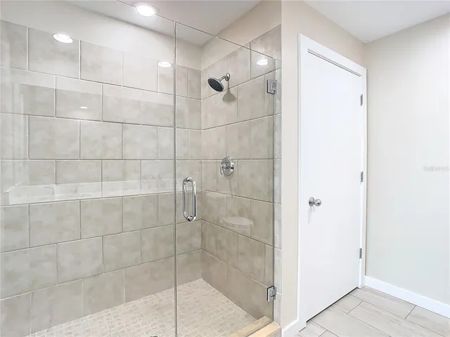 an empty room with wooden floor and ceiling fan
