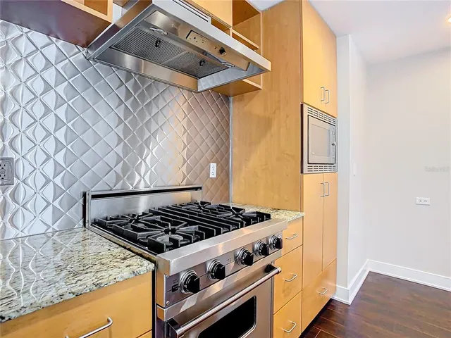 a kitchen with stainless steel appliances granite countertop a stove and a refrigerator