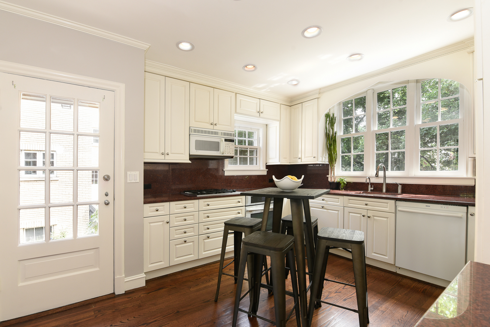 411 Ridge Road Kenilworth, IL 60043 - Photo 18 of 35 a kitchen with stainless steel appliances granite countertop a stove top oven a sink dishwasher a dining table and chairs with wooden floor