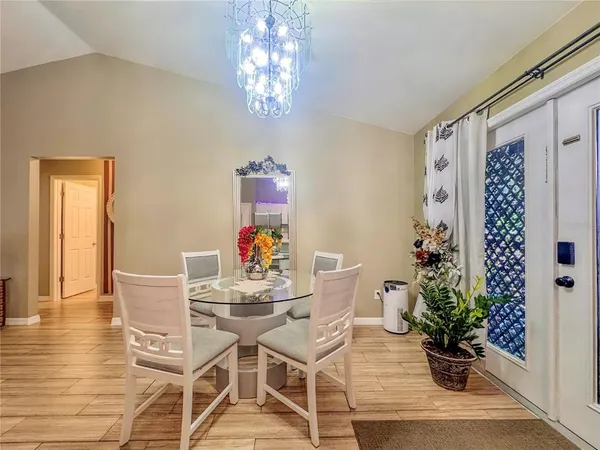 a dining room with furniture potted plants and wooden floor