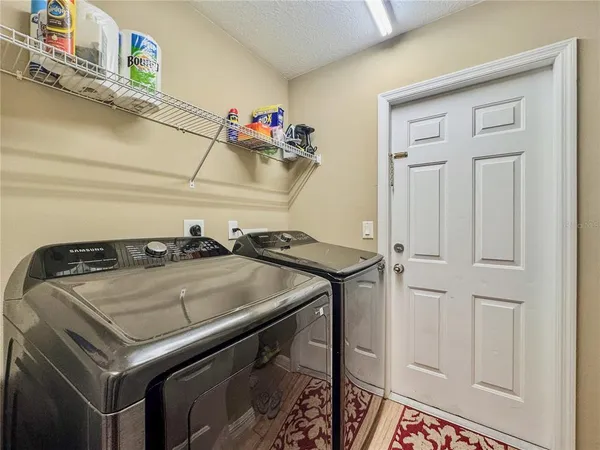 a view of a white house with a big yard and large trees