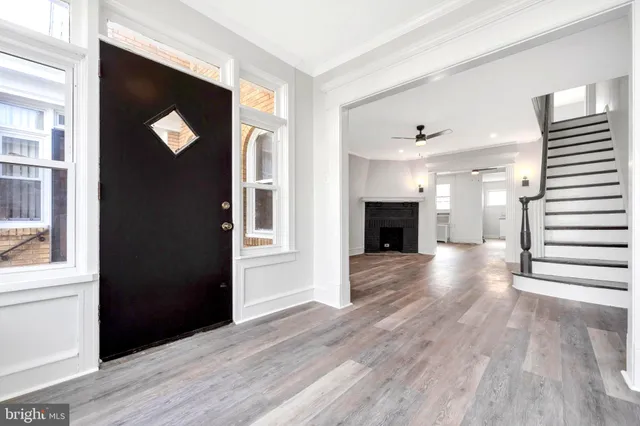 a view of a hallway with wooden floor and staircase