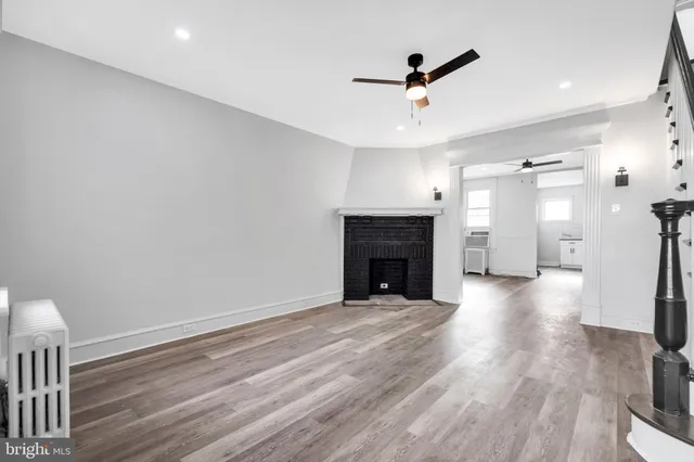 a view of empty room with wooden floor and fireplace