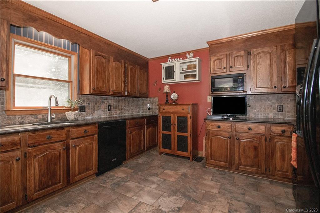 8869 Holdsclaw Road Terrell, NC 28682 - Photo 11 of 37 a kitchen with stainless steel appliances granite countertop a stove sink microwave and cabinets