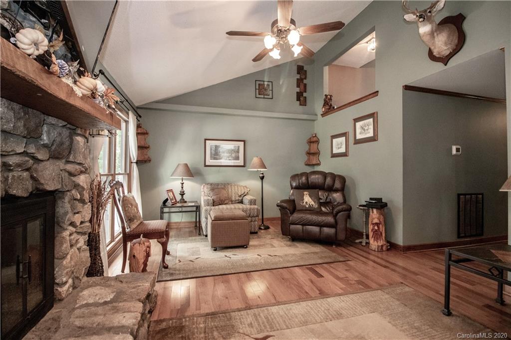 8869 Holdsclaw Road Terrell, NC 28682 - Photo 12 of 37 a living room with furniture a chandelier fan and a fireplace
