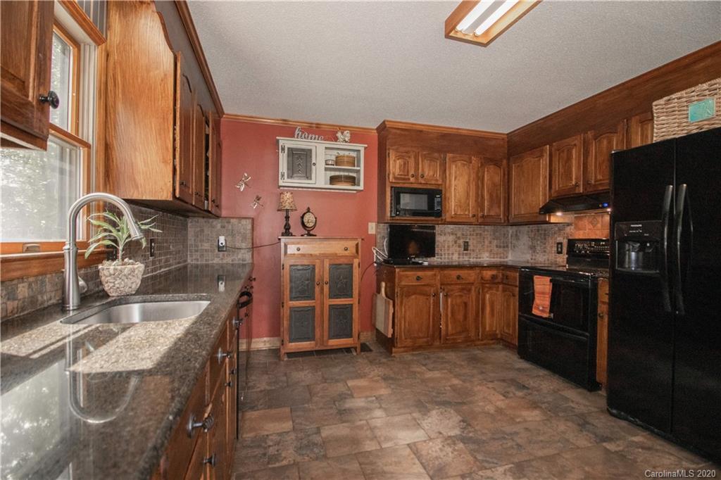 8869 Holdsclaw Road Terrell, NC 28682 - Photo 10 of 37 a kitchen with granite countertop a sink stove and refrigerator