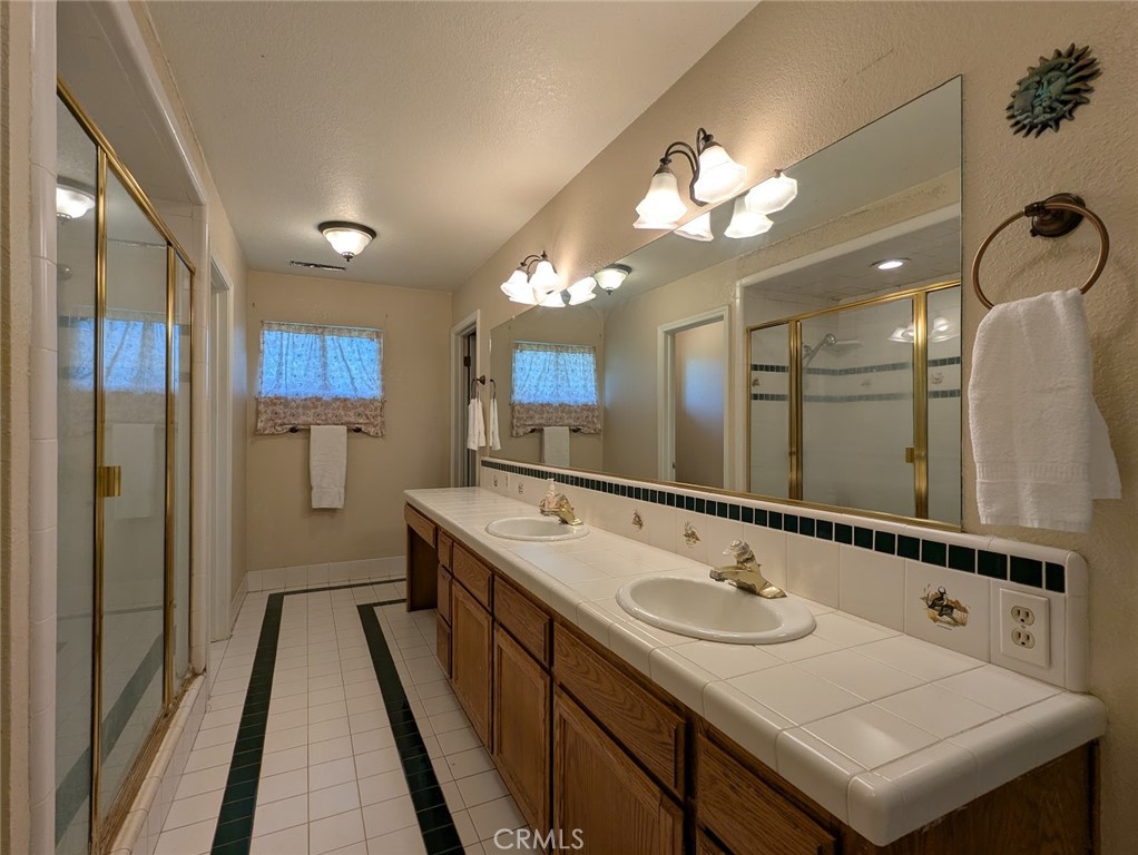 2304 Hutton Way Durham, CA 95938 - Photo 28 of 43 a bathroom with a sink a large mirror and a shower