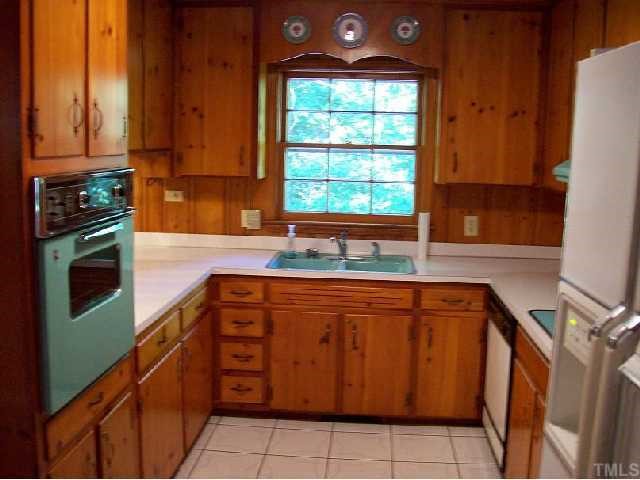 4810 Oak Park Road Raleigh, NC 27612 - Photo 9 of 12 Original knotty pine cabinets in the kitchen with the original appliances...all function as when built...kitchen has a bar area to the nook