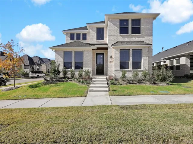 a front view of a house with yard and green space