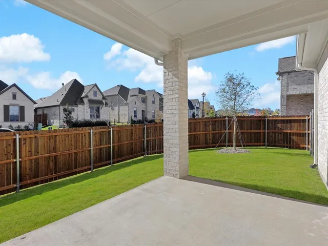 a view of a field with a big yard and wooden fence