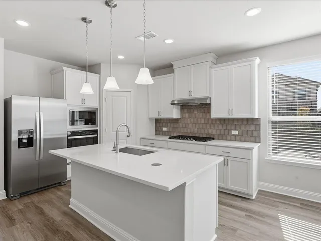 a kitchen with a stove a sink and a refrigerator