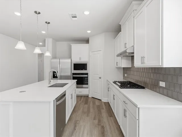 a kitchen with a refrigerator a sink and cabinets