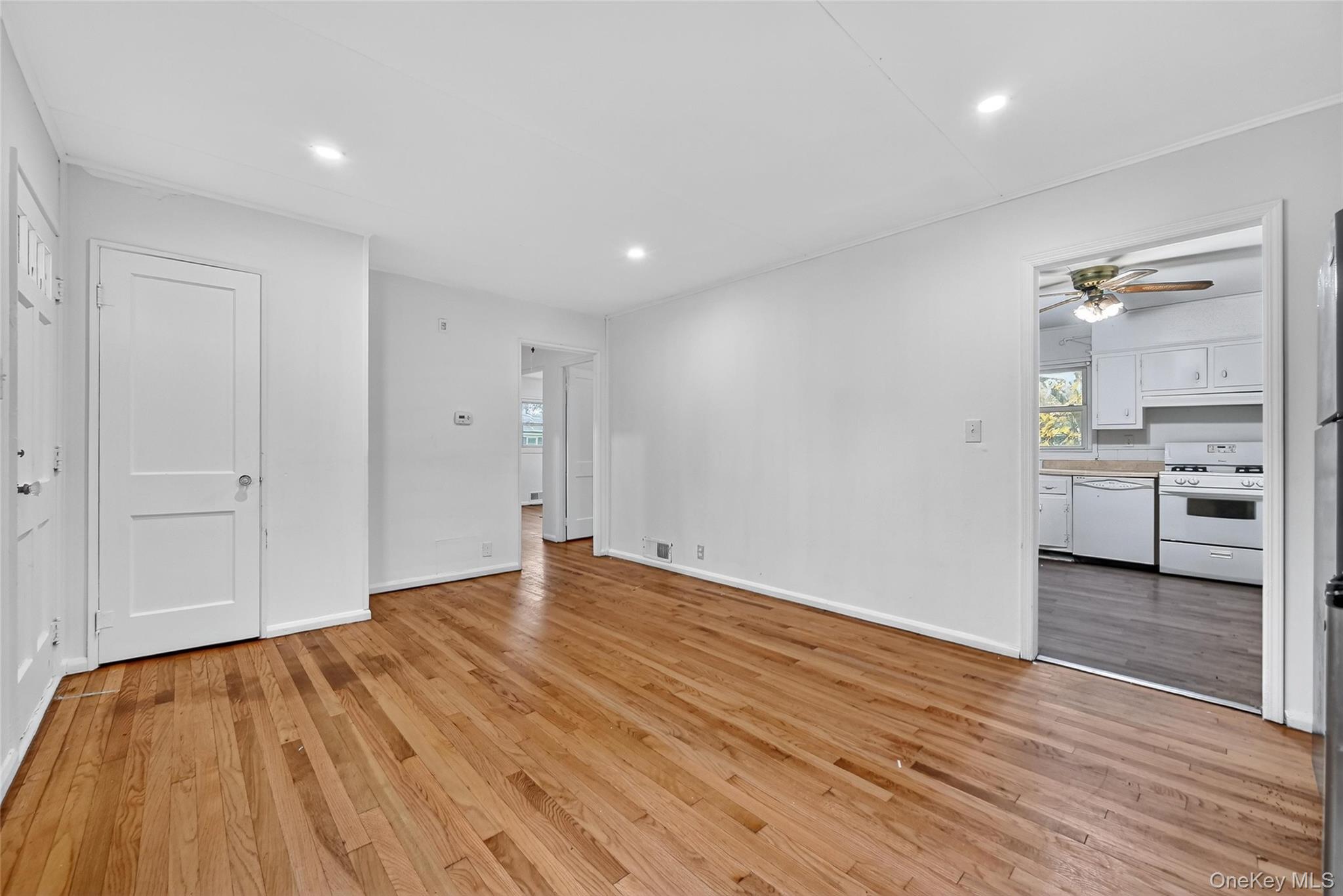 106 East Eckerson Road Spring Valley, NY 10977 - Photo 11 of 33 a view of an empty room with wooden floor and a kitchen