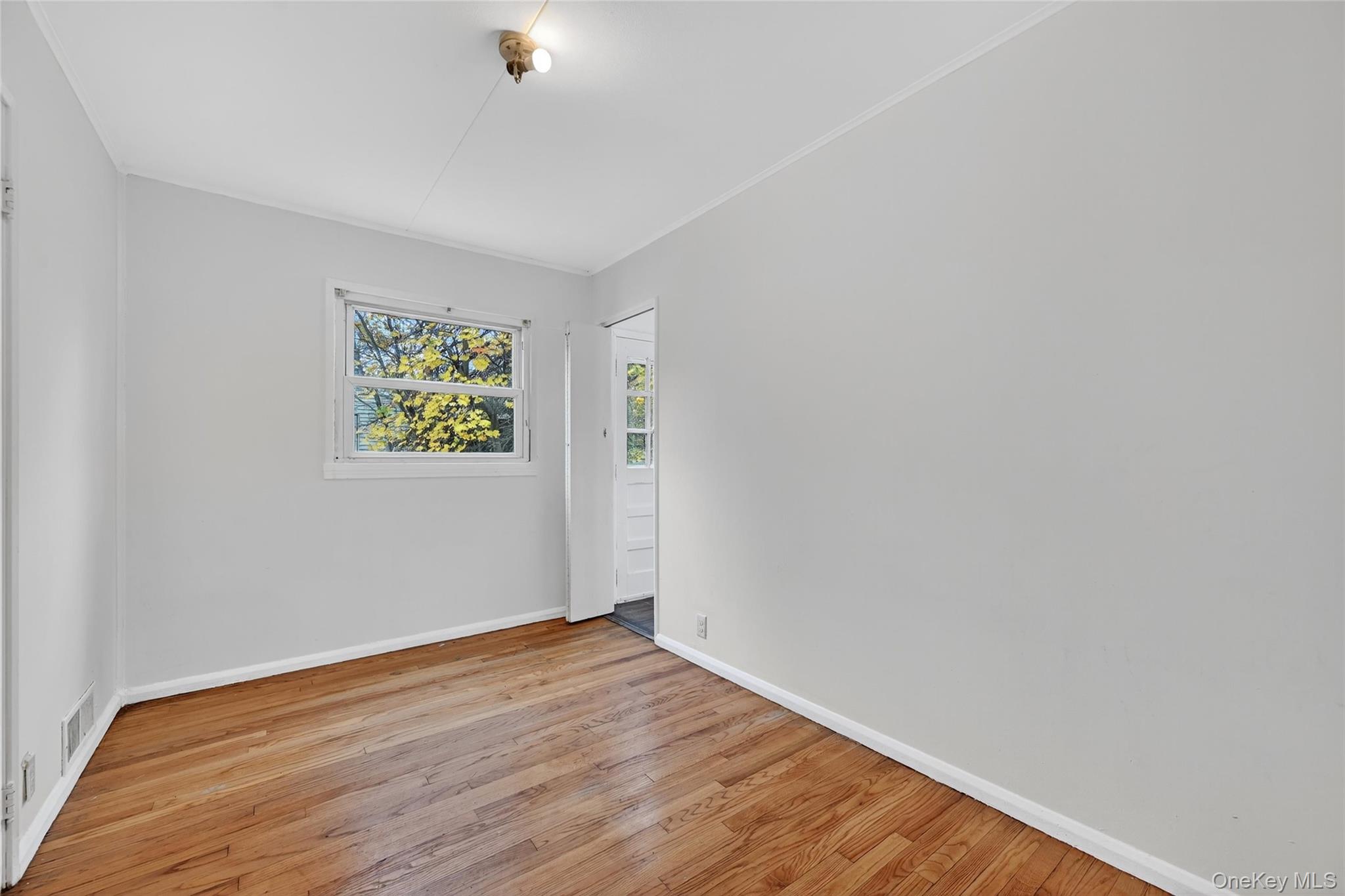 106 East Eckerson Road Spring Valley, NY 10977 - Photo 21 of 33 a view of an empty room with wooden floor and a window