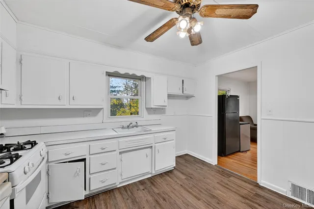 a kitchen with a white cabinets and chandelier