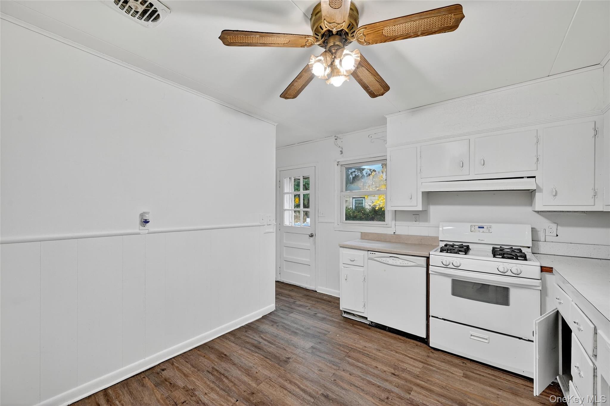 106 East Eckerson Road Spring Valley, NY 10977 - Photo 8 of 33 a kitchen with stainless steel appliances white cabinets and wooden floor
