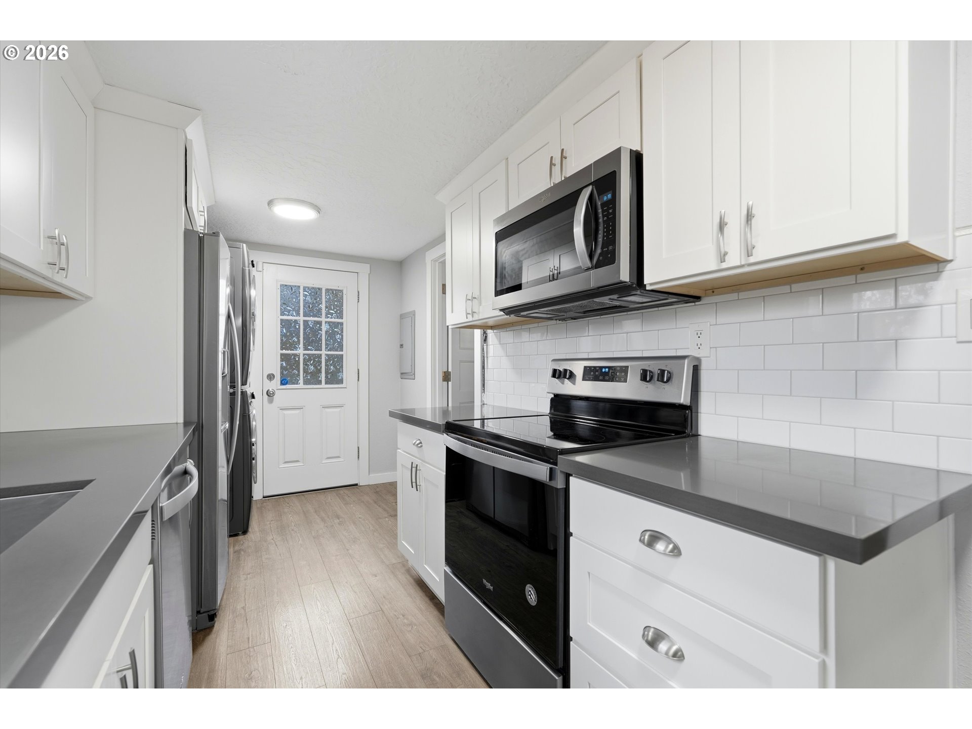 285 19th Avenue Longview, WA 98632 - Photo 11 of 27 a kitchen with stainless steel appliances granite countertop white cabinets a microwave a sink and a refrigerator