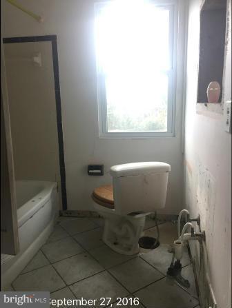 7929 Wynbrook Road Baltimore, MD 21224 - Photo 8 of 10 a white toilet sitting next to a bath tub
