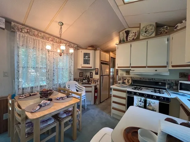 a kitchen with a table chairs stove and cabinets