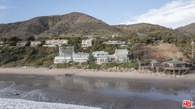 an aerial view of residential house and sandy dunes