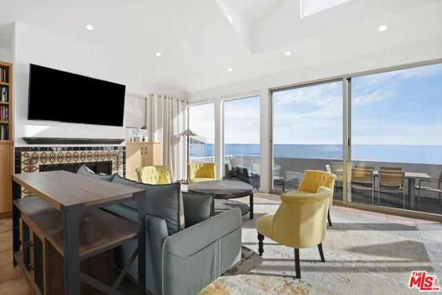 a view of a livingroom with furniture flat screen tv and floor to ceiling window