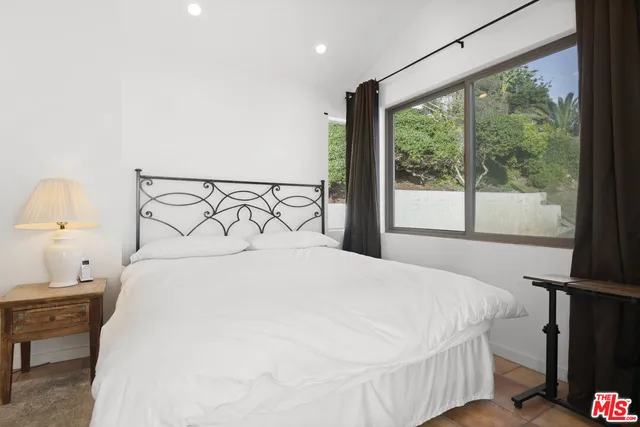 a large bed sitting in a bedroom next to a window