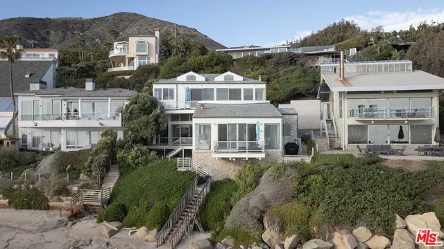 a front view of a residential houses with yard and mountain view in back