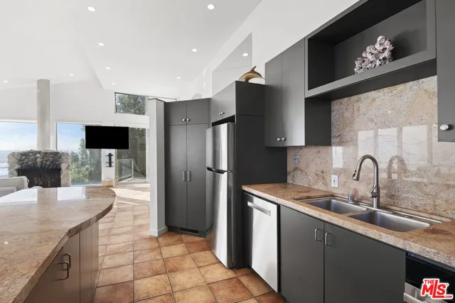 a kitchen with stainless steel appliances granite countertop a sink refrigerator and microwave