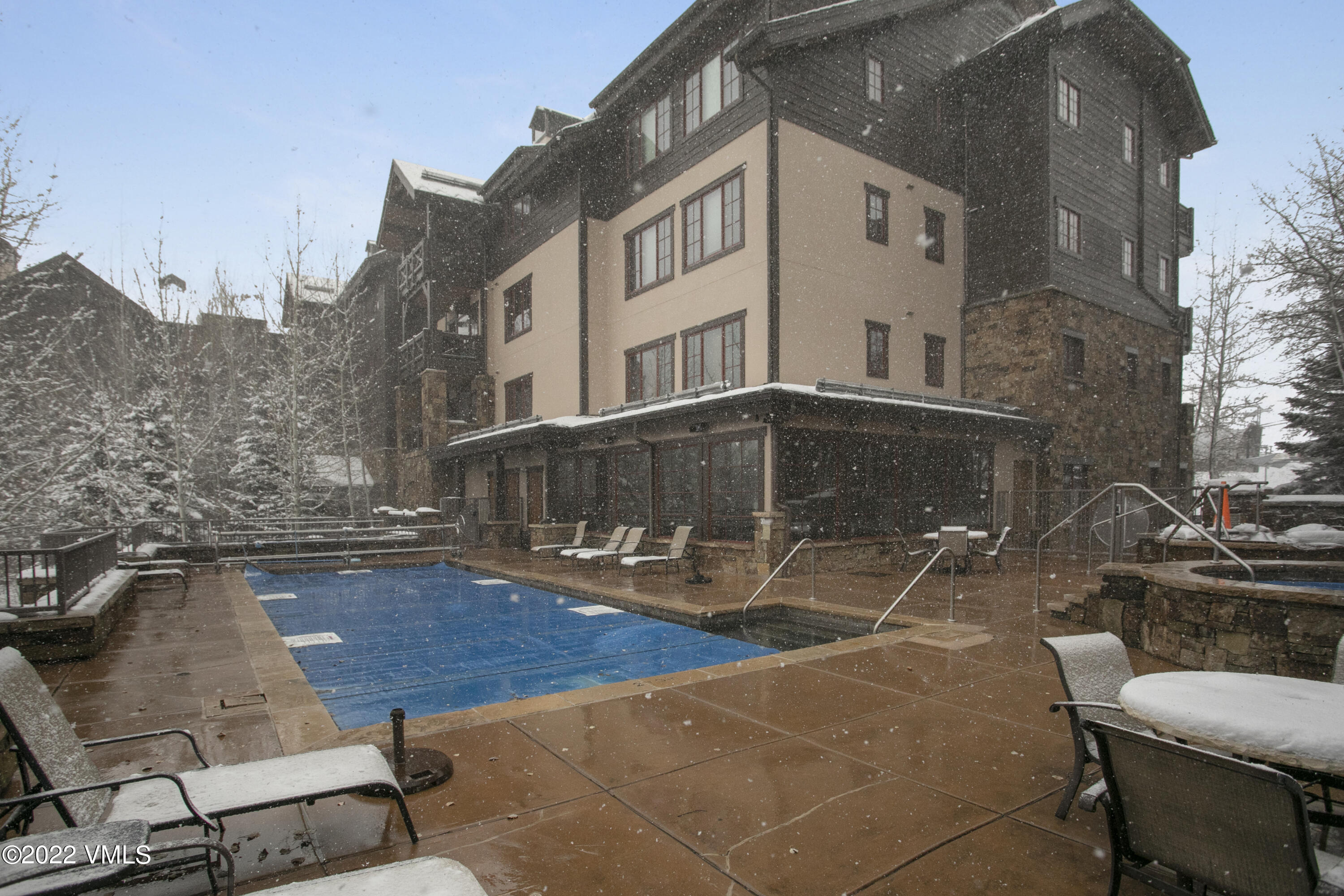 300 Prater Road, Unit B303 Beaver Creek, CO 81620 - Photo 22 of 38 a view of a patio with table and chairs with wooden floor and fence