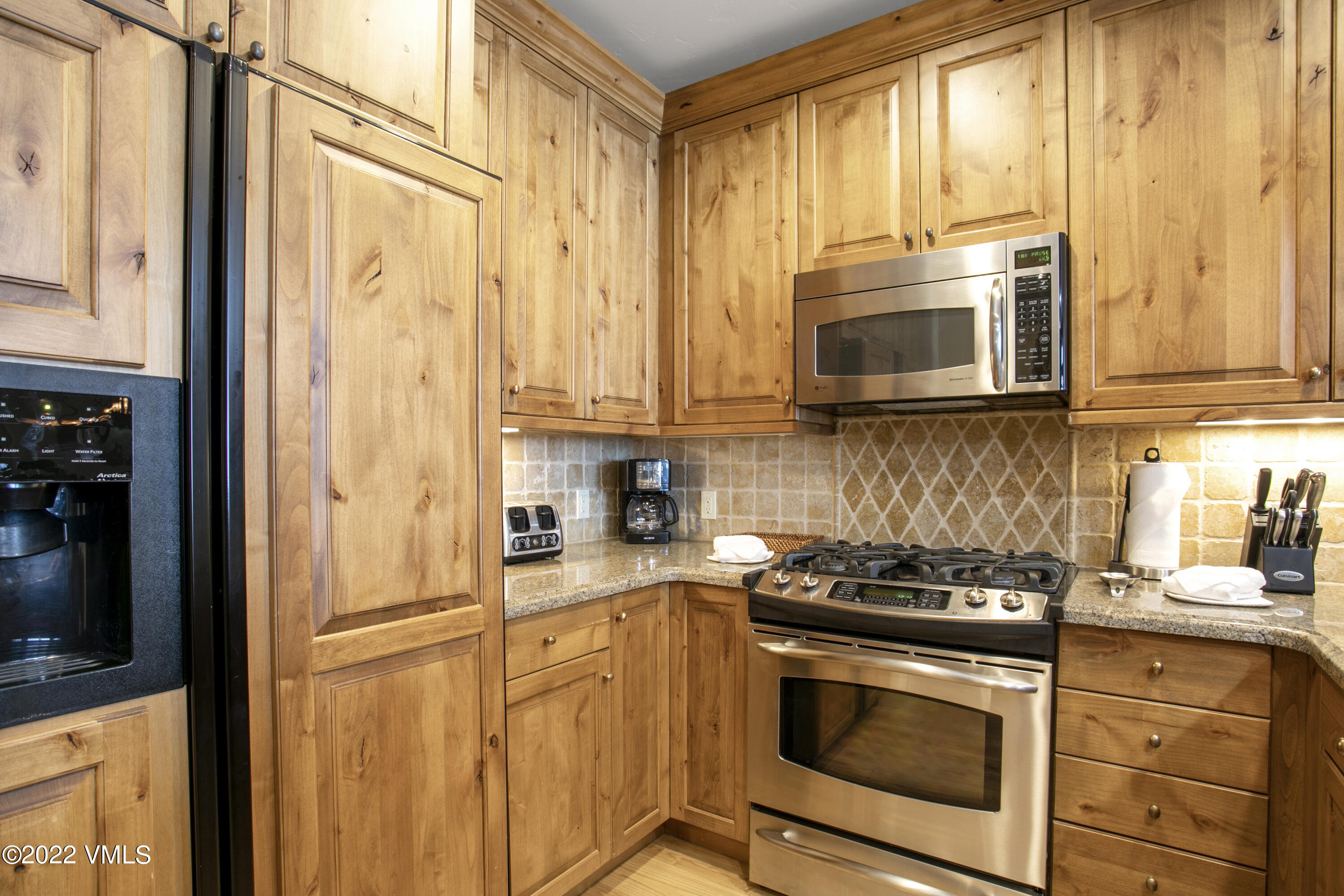 300 Prater Road, Unit B303 Beaver Creek, CO 81620 - Photo 9 of 38 a kitchen with stainless steel appliances granite countertop cabinets and a microwave oven