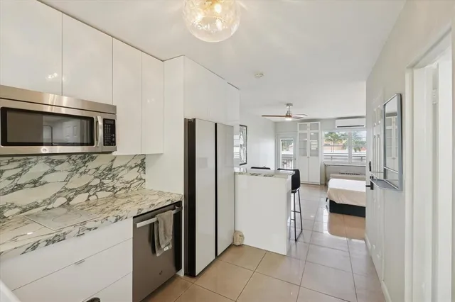 a kitchen with stainless steel appliances granite countertop a refrigerator and a stove top oven