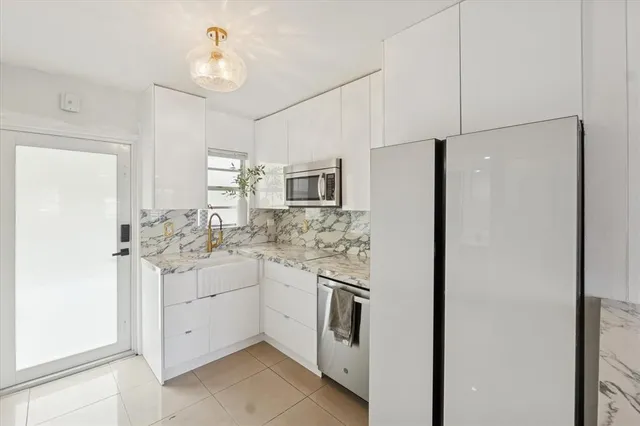 a kitchen with white cabinets and white appliances