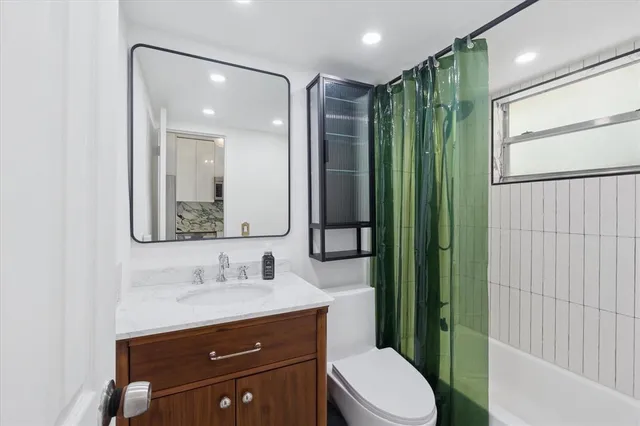 a bathroom with a toilet a sink and mirror