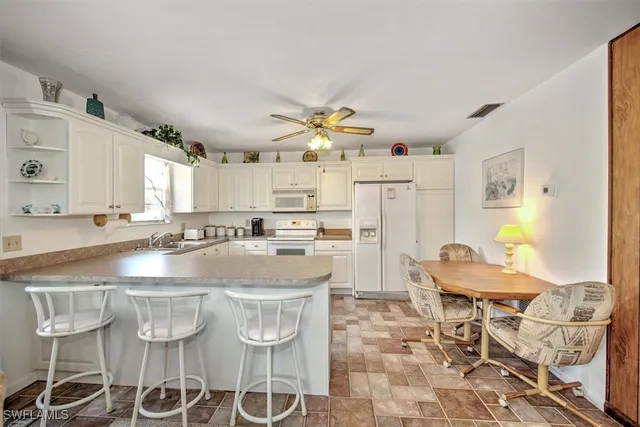 a kitchen with stainless steel appliances kitchen island granite countertop a table and chairs in it