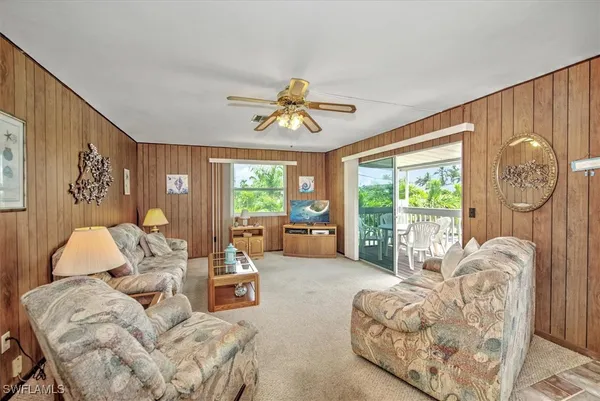 a living room with furniture a chandelier and a large window