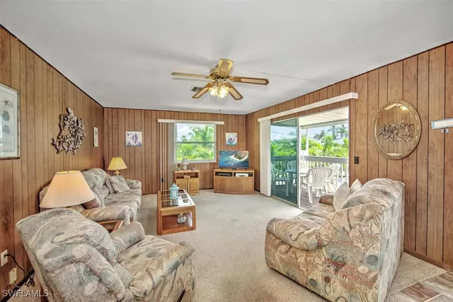 a living room with furniture a chandelier and a large window
