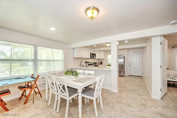 a dining room with furniture and a floor to ceiling window