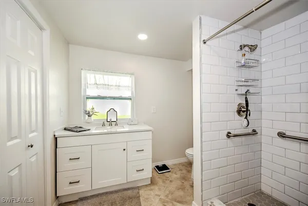 a bathroom with a shower a sink and a mirror