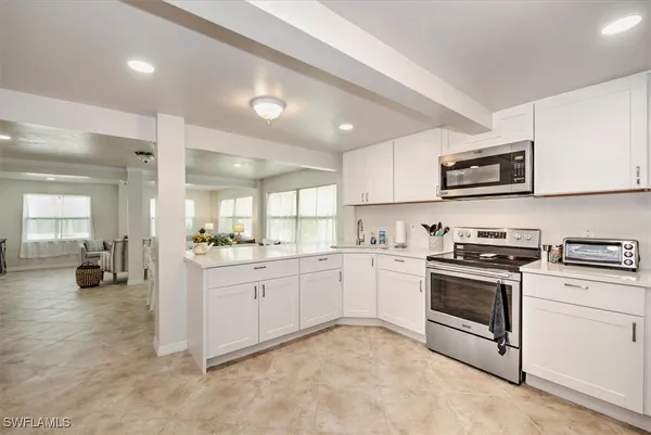a kitchen with granite countertop white cabinets and white appliances