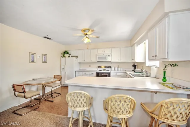 a kitchen with stainless steel appliances granite countertop a stove a sink a dining table and chairs