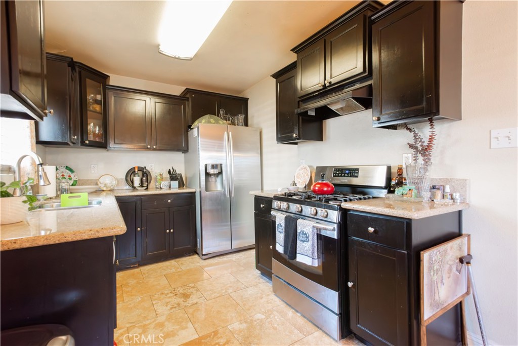 1500 West 156th Street Compton, CA 90220 - Photo 18 of 32 a kitchen with stainless steel appliances granite countertop a sink stove and refrigerator
