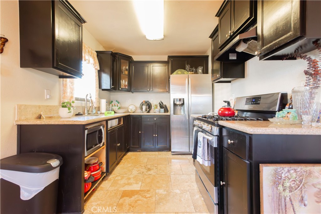 1500 West 156th Street Compton, CA 90220 - Photo 19 of 32 a kitchen with a sink stove and cabinets