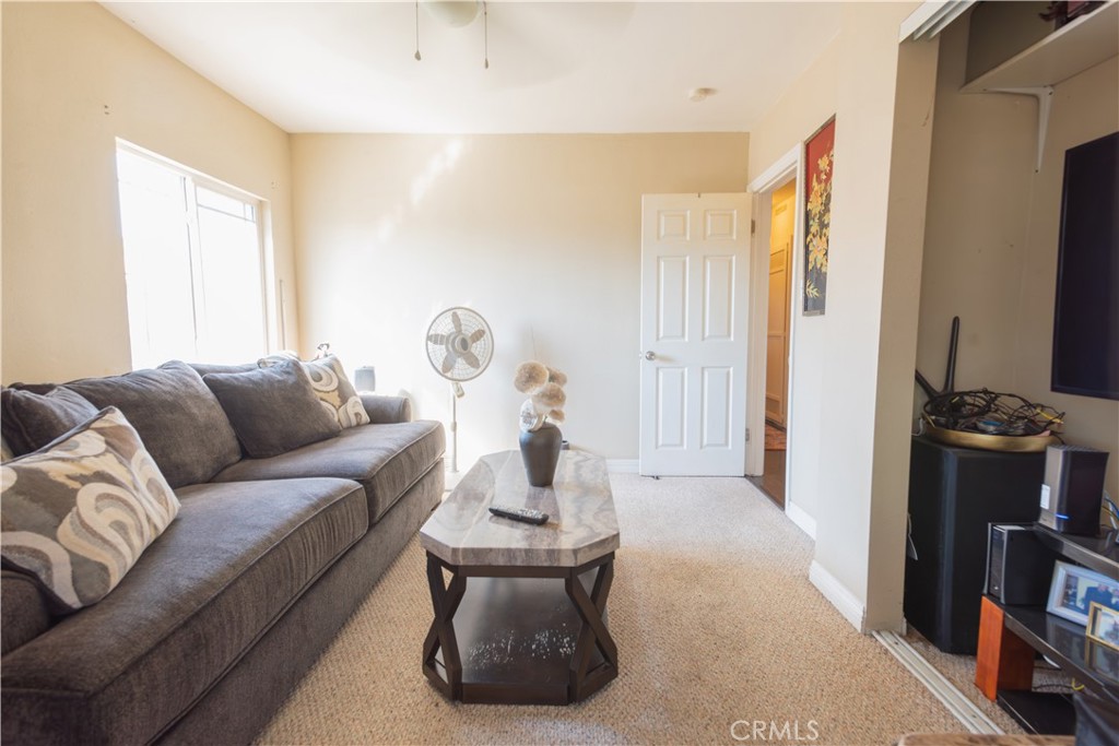 1500 West 156th Street Compton, CA 90220 - Photo 21 of 32 a living room with furniture a flat screen tv and a window