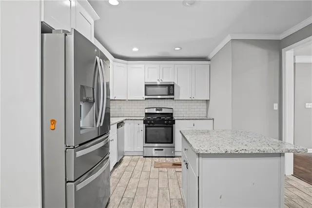 a kitchen with granite countertop a refrigerator and a sink