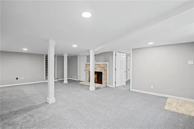 an empty room with fireplace and window