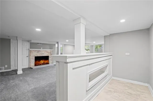 a view of an empty room with a fireplace and window