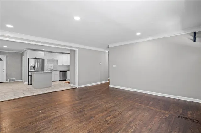 a view of empty room with wooden floor
