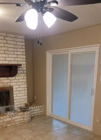 a view of a livingroom with a fireplace and window